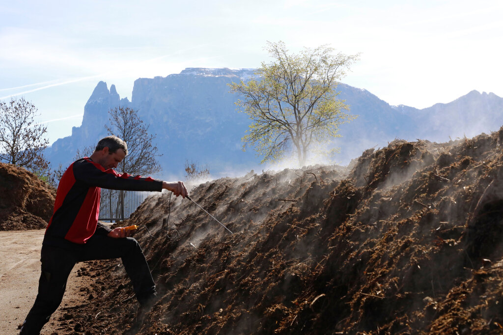 Die Kompostieranlage in Siffian am Ritten ist ein ruhiger Ort mit Blick auf den Schlern: Hansjörg Rottensteiner, Heizwart im Fernheizwerk Ritten, kontrolliert die Temperatur im Komposthaufen. Foto: Alexander Alber