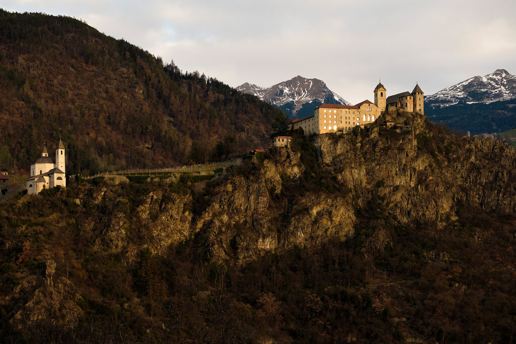 300 Meter über Klausen erhebt sich das Kloster Säben: Früher residierten hier Bischöfe, von 1684 bis 2021 lebten die Benediktinerinnen hinter hohen Klostermauern (oben Kloster, Klosterkirche, Heilig-Kreuz-Kirche, links die Liebfrauenkirche). Foto: Ludwig Thalheimer
