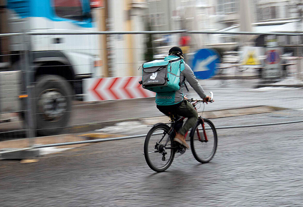 Erst, wenn der Fahrradkurier losradelt, verdient er Geld, er wird nach Minuten bezahlt: Die Männer, die Essen liefern, haben einen harten Job, in der Pandemie waren sie gefragt – auch wenn sich nur die Wenigsten bei ihnen bedanken. Foto: Dominik Hofer