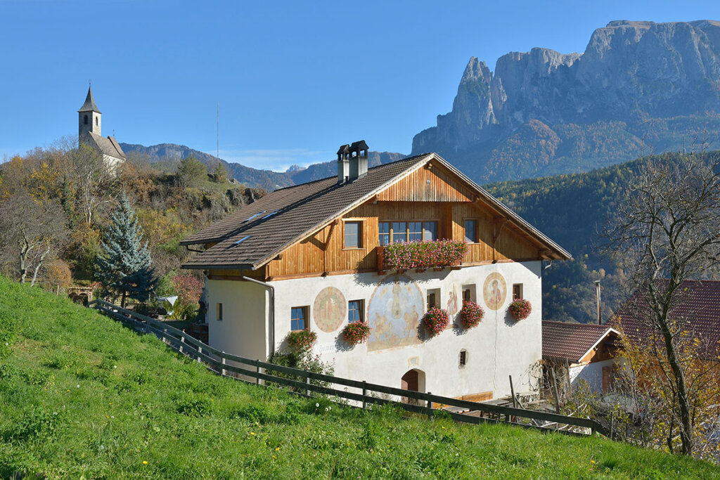 Der Zunerhof in Antlas am Ritten mit Andreaskapelle und Schlern im Hintergrund. Foto: Raetia Verlag