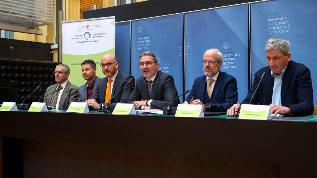 Sechs Männer auf dem Podium, die im Februar 2023 große Worte zur maßgeschneiderten Medizin schwangen, von links: Markus Paulmichl, Wolfgang Schnitzel, Michael Mian, Arno Kompatscher, Florian Zerzer, Josef Widmann. Foto: Südtiroler Sanitätsbetrieb