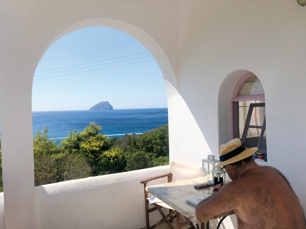 Auf dem Bild straft unser Karikaturist Hans-Peter Demetz jene Lügen, die behaupten man könne Urlaub und Arbeit nicht vereinen: Seine Zeichnung für dieses Heft ist vor griechischem Panorama entstanden. Foto: HPD