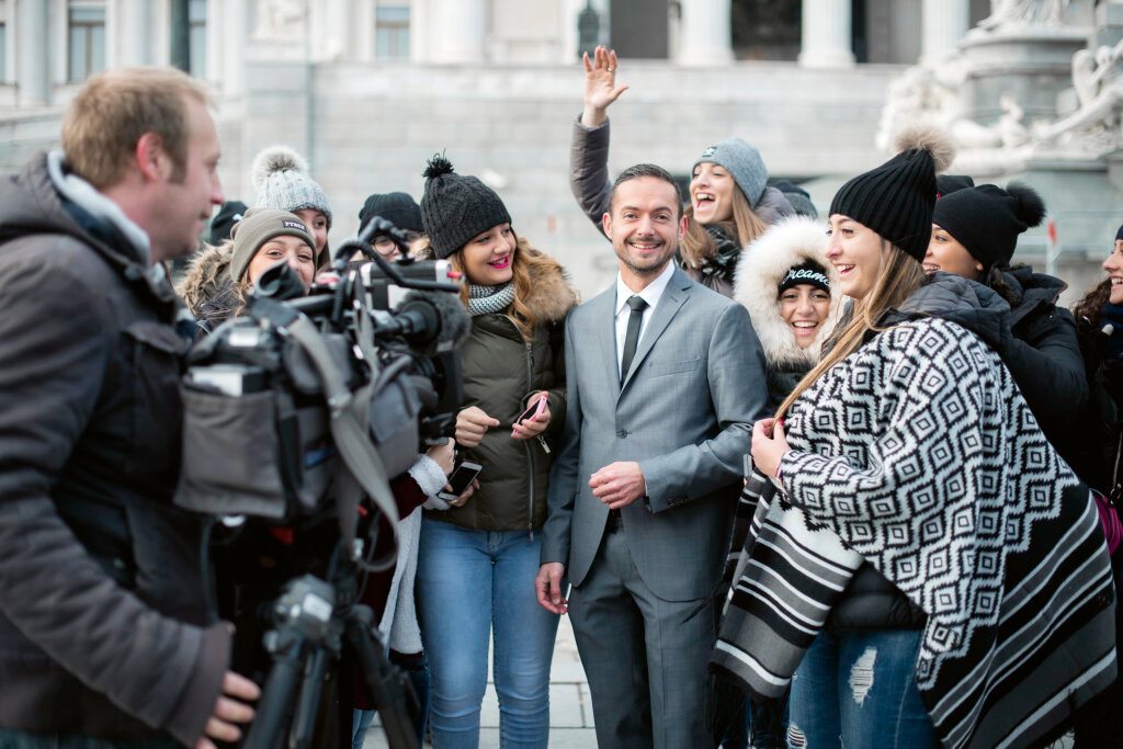 Der Spaß bei der Arbeit bleibt nie aus: Wie hier in Wien, als Alex Lechner von einer Touristengruppe überrannt wird. Foto: Servus TV